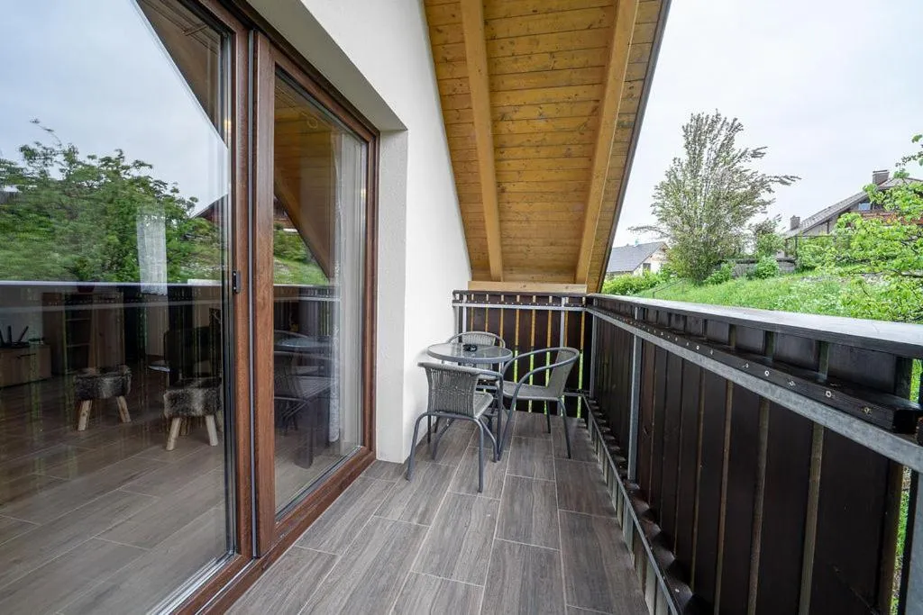 Balkon s stoli in mizico, pogled na travnik