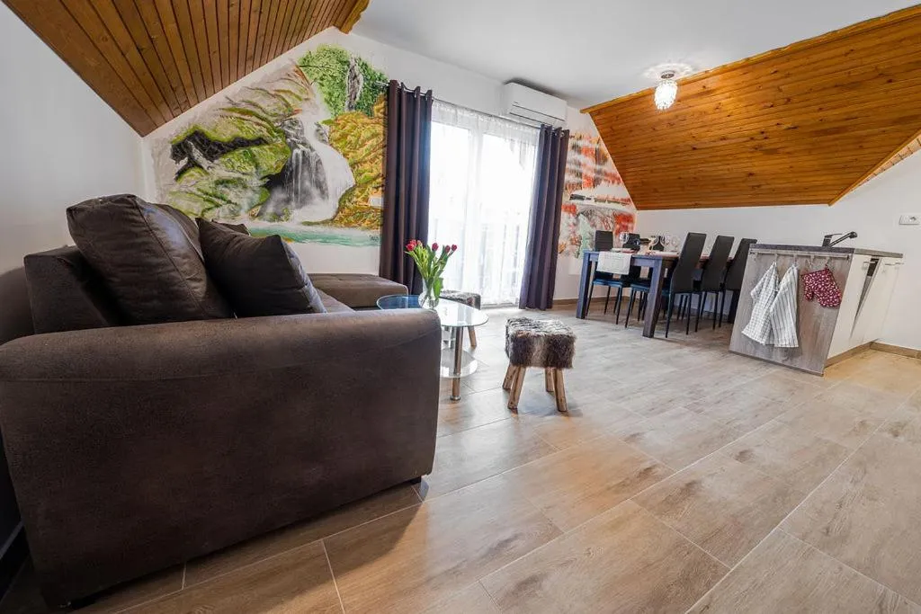 Dnevni prostor apartmaja z balkonom s poslikano steno in jedilno mizo